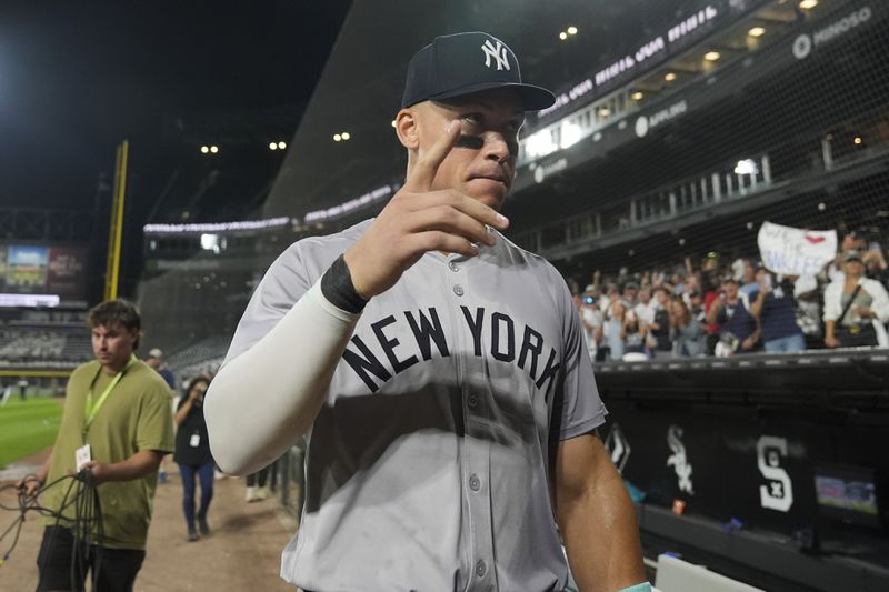 New York Yankees' Aaron Judge signals to fans after he hit his 300th career home run, the fastest player to do so in MLB history, in a baseball game against the Chicago White Sox, Wednesday, Aug. 14, 2024, in Chicago. (AP Photo/Erin Hooley)