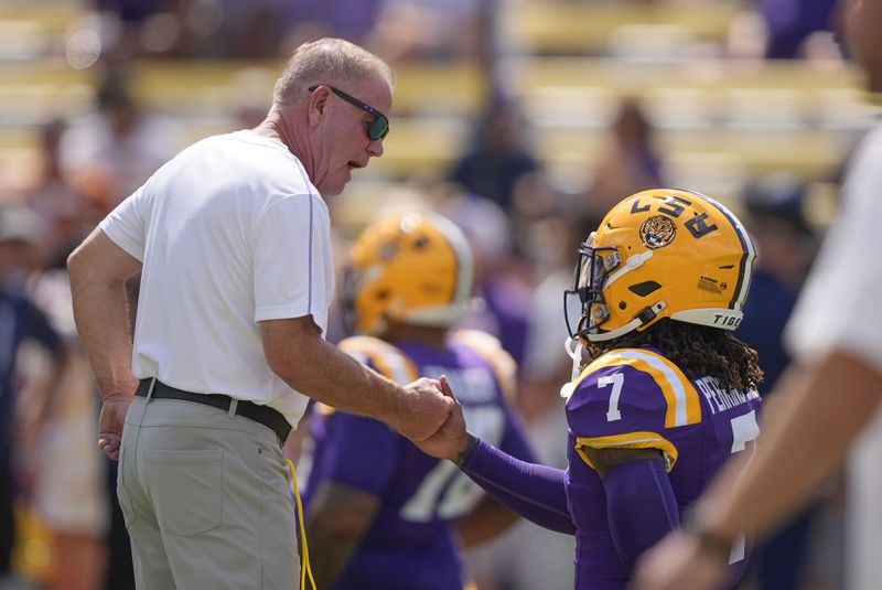 LSU head coach Brian Kelly greets linebacker Harold Perkins Jr. (7) before an NCAA college football game against UCLA in Baton Rouge, La., Saturday, Sept. 21, 2024. (AP Photo/Gerald Herbert)