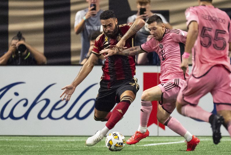 Inter Miami forward Lionel Messi (10), right, and Atlanta United defender Derrick Williams (3) battle for control of the ball during the second half of a MLS soccer match Wednesday, Sept. 18, 2024. (AP Photo/John Bazemore)