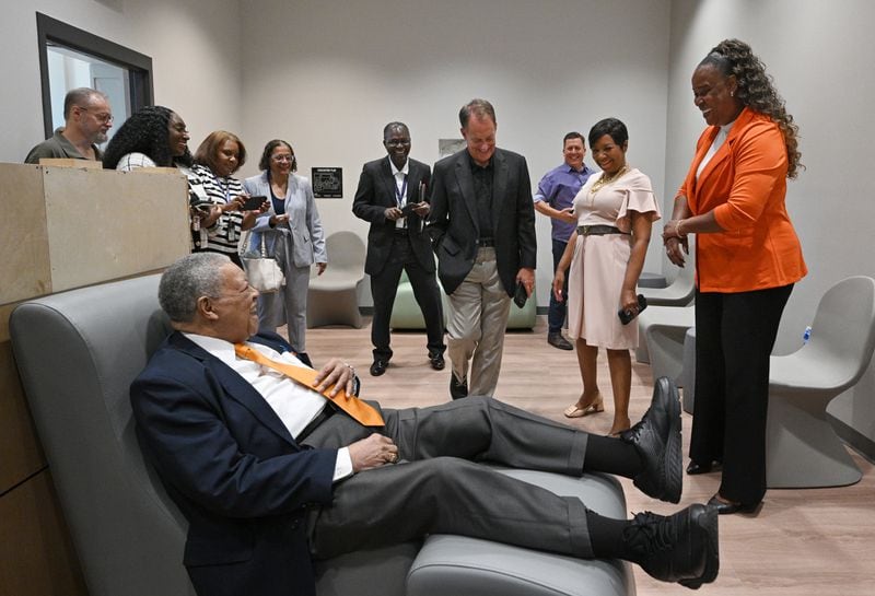 Fulton Commission Chairman Robb Pitts smiles as he sits on a furniture that designed for the center’s clients during a facility tour lead by LaTrina Foster (right), Director of Behavioral Health, at new Fulton County Behavioral Health Crisis Center, on Friday, June 21, 2024 in Atlanta. (Hyosub Shin / AJC)