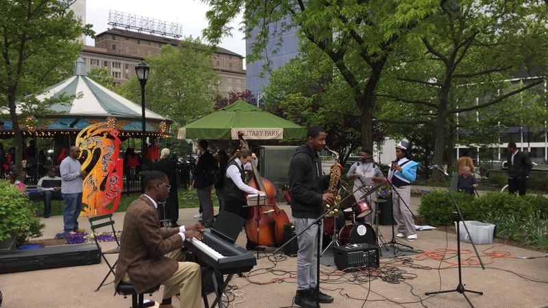 In this May 11, 2017 photo a band performs in Military Park in Newark, N.J. The 6-acre park, which underwent a multimillion-dollar restoration, is a jewel in the city's downtown, with flowerbeds, a carousel, an eatery and other amenities. Riots scarred Newark 50 years ago this summer, but tourism officials are hoping to attract more visitors as the city charts its comeback.  (AP Photo/Beth J. Harpaz)