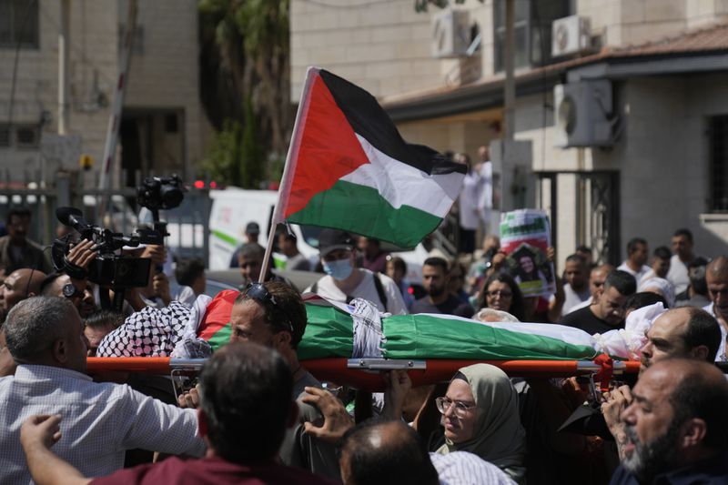 Mourners carry the body of Aysenur Ezgi Eygi, 26, who was fatally shot by Israeli soldiers while participating in an anti-settlement protest in the West Bank, during her funeral procession in the West Bank city of Nablus, Monday, Sept. 9, 2024. (AP Photo/Nasser Nasser)