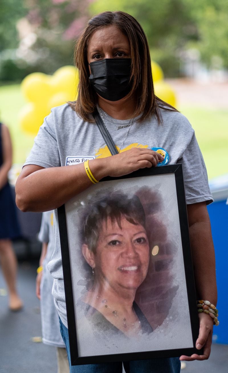 Melissa Rice holds a photo of her mother, Miriam Pabon, who died from COVID-19.  Rice was among those taking part in a gathering at St. Luke’s Episcopal Church in Atlanta on Saturday morning, August 7, 2021, as part of National COVID Awareness Day. (Photo: Ben Gray for The Atlanta Journal-Constitution)