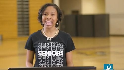 A screenshot of Lauren Hester, valedictorian of Coretta Scott King Young Women's Leadership Academy in Atlanta, as she gives a speech in an empty gym during a video celebrating graduation.