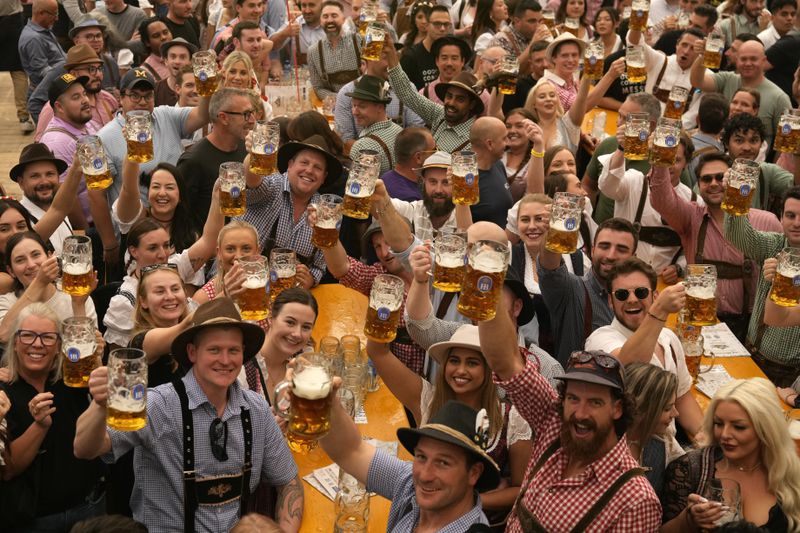 Festival enjoy the first glasses of beer on day one of the 189th 'Oktoberfest' beer festival in Munich, Germany, Saturday, Sept. 21, 2024. (AP Photo/Matthias Schrader)