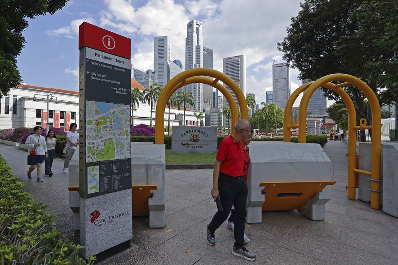 People walk outside Parliament House complex, where Pope Francis is scheduled to meet Singapore Prime Minister Lawrence Wong and President Tharman Shanmugaratnam, in Singapore, Saturday, Sept. 7, 2024. (AP Photo/Suhaimi Abdullah)