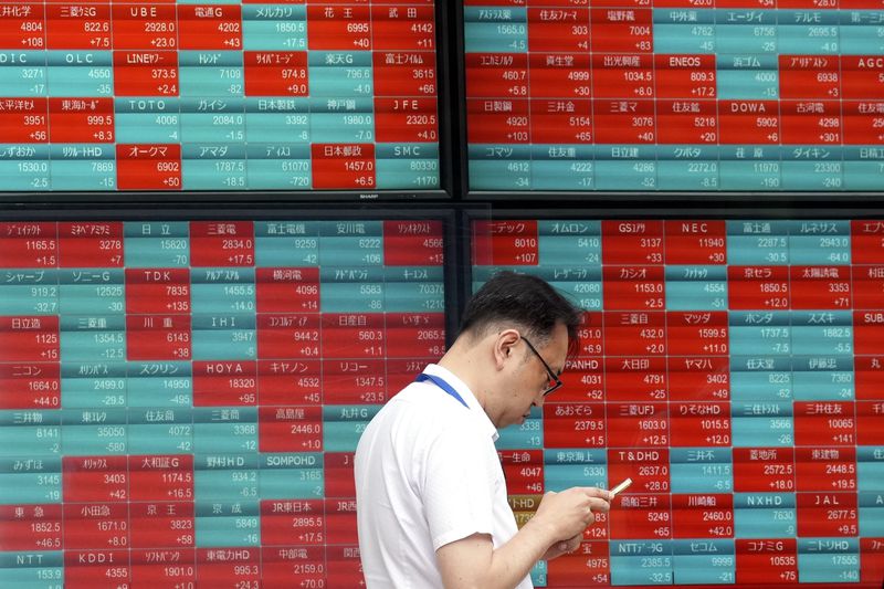 FILE - A person stands in front of an electronic stock board showing Japan's Nikkei index at a securities firm in Tokyo, on May 28, 2024. (AP Photo/Eugene Hoshiko, File)