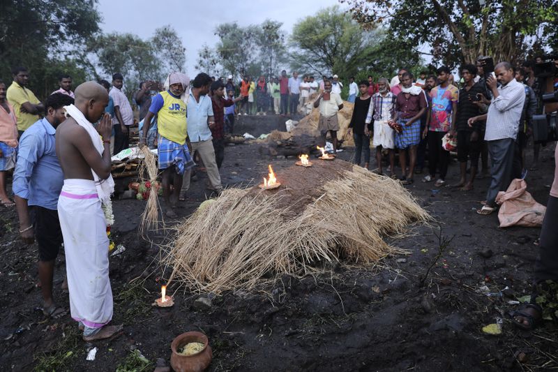 A boy with his head shaved prays before lighting the funeral pyre of his father, who died after drinking illegally brewed liquor, in Kallakurichi district of the southern Indian state of Tamil Nadu, India, Thursday, June 20, 2024. The state's chief minister M K Stalin said the 34 died after consuming liquor that was tainted with methanol, according to the Press Trust of India news agency. (AP Photo/R. Parthibhan)