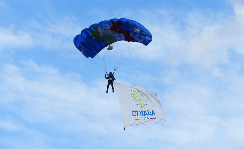 A skydiver flies with a G7 Italia flag as the Italian skydiving team puts on an exhibition for world leaders during the G7 Summit in Borgo Egnazia, Italy on Thursday, June 13, 2024. (Sean Kilpatrick/The Canadian Press via AP)