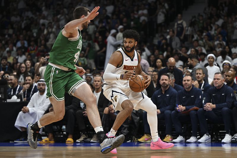 Boston Celtics Luke Kornet guards Denver Nuggets Jamal Murray during a preseason game between Boston Celtics and Denver Nuggets in Abu Dhabi, United Arab Emirates, Friday, Oct. 4, 2024. (AP Photo/Martin Dokoupil)