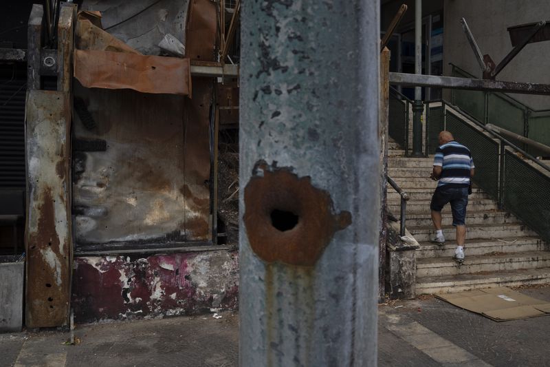 A man walks past a damaged shop, from previous shelling attacks from Lebanon, in Kiryat Shmona, northern Israel, Tuesday, Sept. 17, 2024. (AP Photo/Leo Correa)