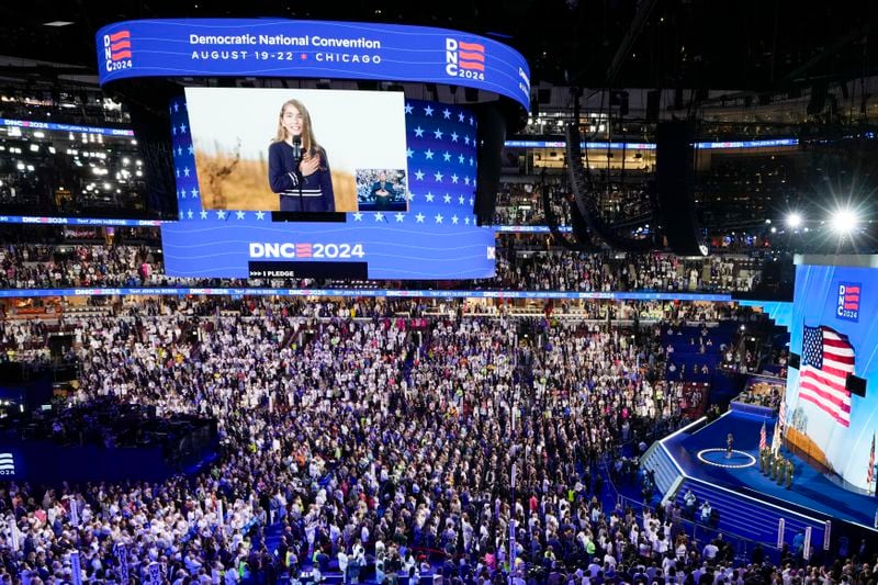 People in the crowd wear white during the Pledge of Alliegence during the Democratic National Convention Thursday, Aug. 22, 2024, in Chicago. (AP Photo/Morry Gash)