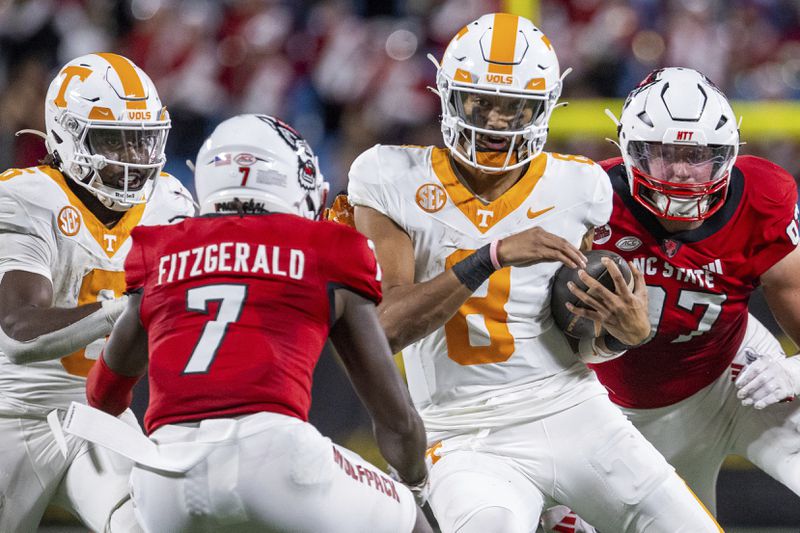 Tennessee quarterback Nico Iamaleava (8) cuts back into North Carolina State safety Bishop Fitzgerald (7) during the second half of an NCAA college football game Saturday, Sept. 7, 2024, in Charlotte, N.C. (AP Photo/Scott Kinser)