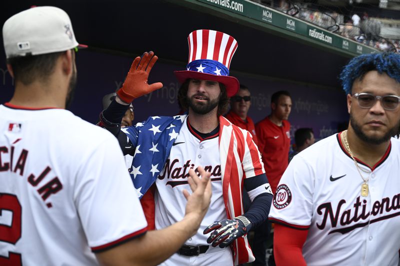 Washington Nationals' Jesse Winker, center, celebrates his home run with Luis Garcia Jr., left, and Harold Ramírez, right, during the eighth inning of a baseball game against the New York Mets, Thursday, July 4, 2024, in Washington. The Nationals won 1-0. (AP Photo/Nick Wass)
