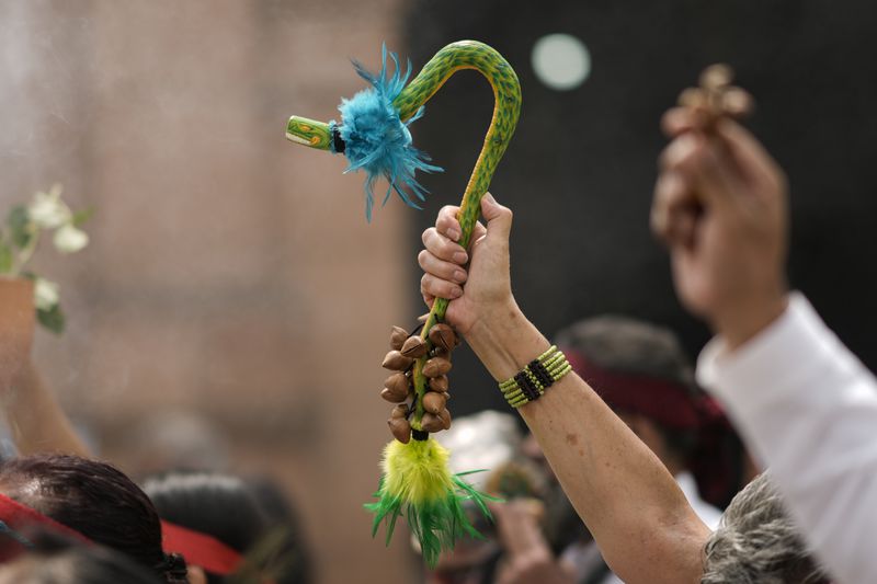 Residents and members of an Amaxac Indigenous organization hold an statue of a feathered serpent, Quetzalcoatl, during a ceremony commemorating the 503 anniversary of the fall of the Aztec empire's capital, Tenochtitlan, in Mexico City, Friday, Aug. 9, 2024. (AP Photo/Eduardo Verdugo)