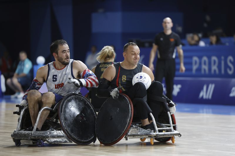 Chuck Aoki from the U.S., left, competes with Germany's Steffen Wecke during their wheelchair rugby match at the Paralympic Games in Paris, Saturday, Aug. 31, 2024. (AP Photo/Mady Mertens)