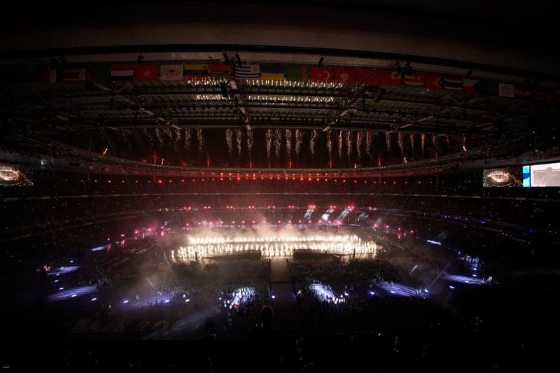 Spectators attend the closing ceremony of the 2024 Paralympics under the rain, Sunday, Sept. 8, 2024, in Paris, France. (AP Photo/Christophe Ena)