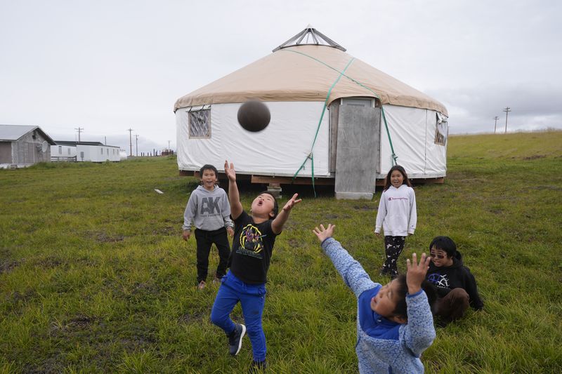 Children play along the tundra on Friday, Aug. 16, 2024, in Mertarvik, Alaska. (AP Photo/Rick Bowmer)