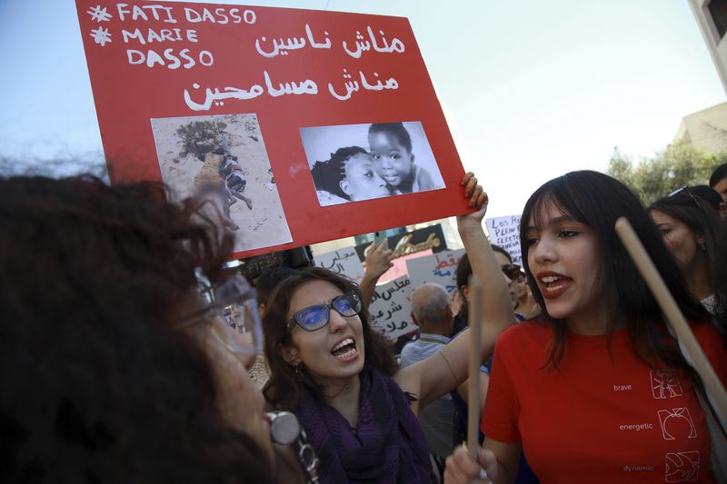 Members of the opposition and civil society groups shout slogans and wave placards during a demonstration against Tunisia president Kais Saied, ahead of the upcoming presidential elections, in Tunis, Friday, Sept. 27, 2024. Banner in Arabic reads: "We will not forgive, we will not forget." (AP Photo/Anis Mili)