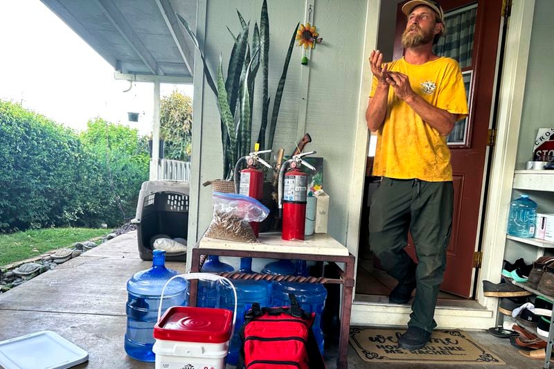 Chris Cole speaks to the Associated Press about evacuating from last year's wildfires as he displays an emergency kit and a bag with essentials that he can quickly grab if he has to flee flames again at his home on Thursday, July 18, 2024, in Kula, Hawaii. (AP Photo/Jennifer Sinco Kelleher)