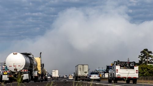 Westbound traffic on I-20 approach the plume of smoke rising from BioLab that continued on Thursday, Oct. 3, 2024 in Conyers. A Sunday fire at the chemical plant in Conyers has had agencies monitoring the air quality since then as crews try to neutralize the site. Rockdale County officials said that the plume is changing colors as workers remove debris. GEMA has advised anyone who notices a chlorine odor in the air to limit their time outdoors. (John Spink/AJC)