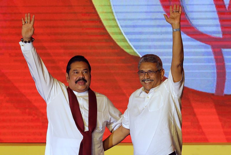 FILE - Mahinda Rajapaksa, left, and his brother Gotabaya Rajapaksa wave to supporters during a party convention held to announce Gotabaya's presidential candidacy in Colombo, Sri Lanka, Aug. 11, 2019. (AP Photo/Eranga Jayawardena, File)