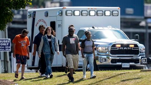 Students and parents walk off campus at Apalachee High School, Wednesday, Sept. 4, 2024, in Winder, Ga. A shooting at the Georgia high school Wednesday caused an unknown number of injuries and a suspect was arrested in a chaotic scene. (AP Photo/Mike Stewart)