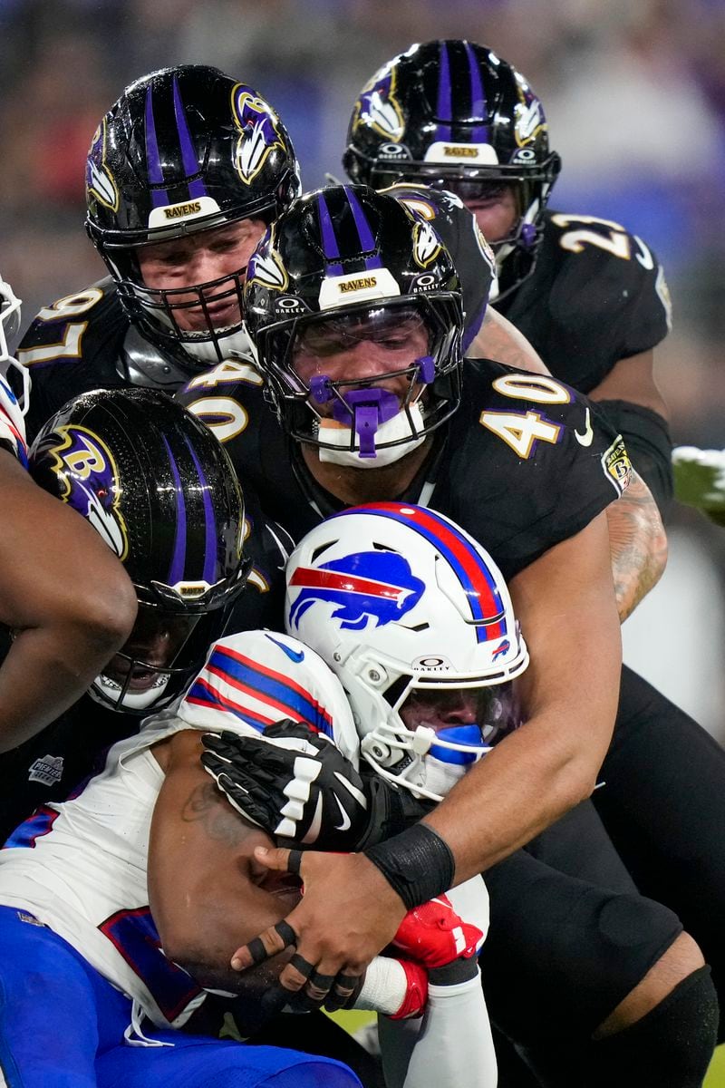 Baltimore Ravens linebacker Malik Harrison (40) and teammates help bring down Buffalo Bills running back Ray Davis, bottom, during the second half of an NFL football game, Sunday, Sept. 29, 2024, in Baltimore. (AP Photo/Stephanie Scarbrough)