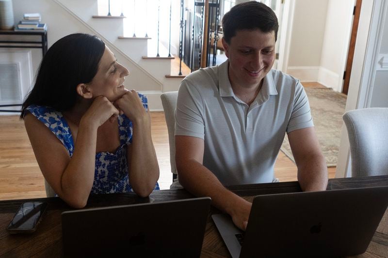 Scott Arogeti and Jordan Arogeti talk while working on their computers from their home on Tuesday, June 27, 2023 in Atlanta. The couple co-founded a website giving people the opportunity to better support loved ones going through tough times. (Michael Blackshire/Michael.blackshire@ajc.com)

