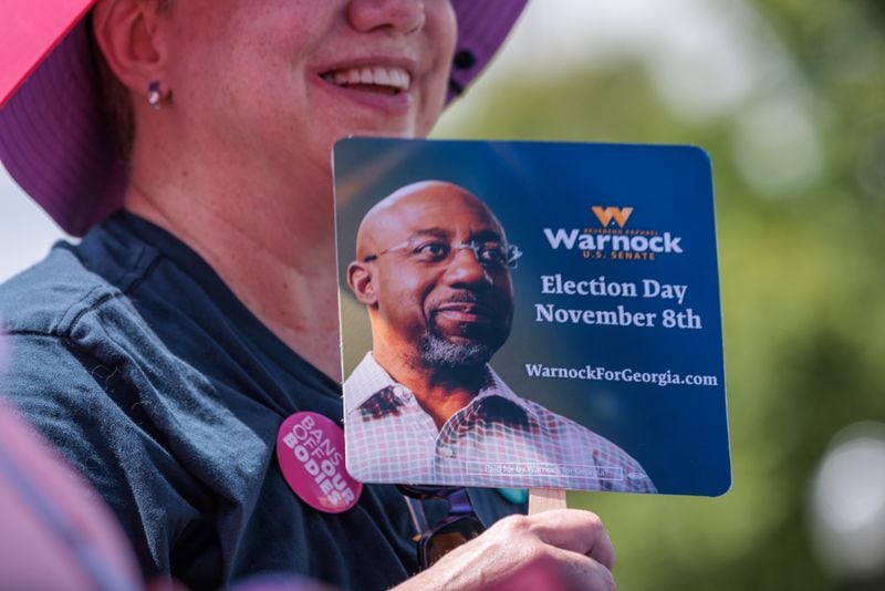 A supporter cools themselves with a fan during a speech by U.S. Sen. Raphael Warnock at a campaign stop in Newnan on Aug. 30, 2022. (Arvin Temkar / arvin.temkar@ajc.com)