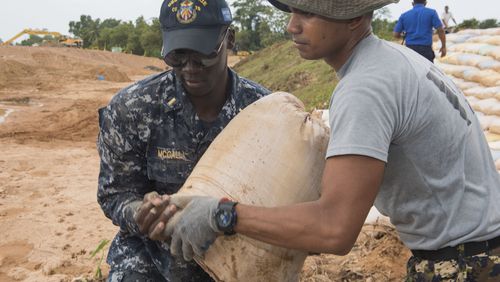 Morehouse graduate Lt. j.g. Asante McCalla (left) worked to repair levees in Matara, Sri Lanka, June 12, 2017, during humanitarian assistance operations.