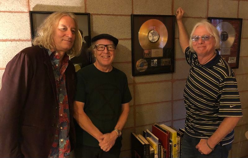 From left, Peter Buck, Mitch Easter and Mike Mills surround the award that certified R.E.M's 1984 "Reckoning" as a gold album. The award for "Reckoning," produced by Easter, hangs on the wall at his studio in North Carolina. Photo: Courtesy of The Baseball Project