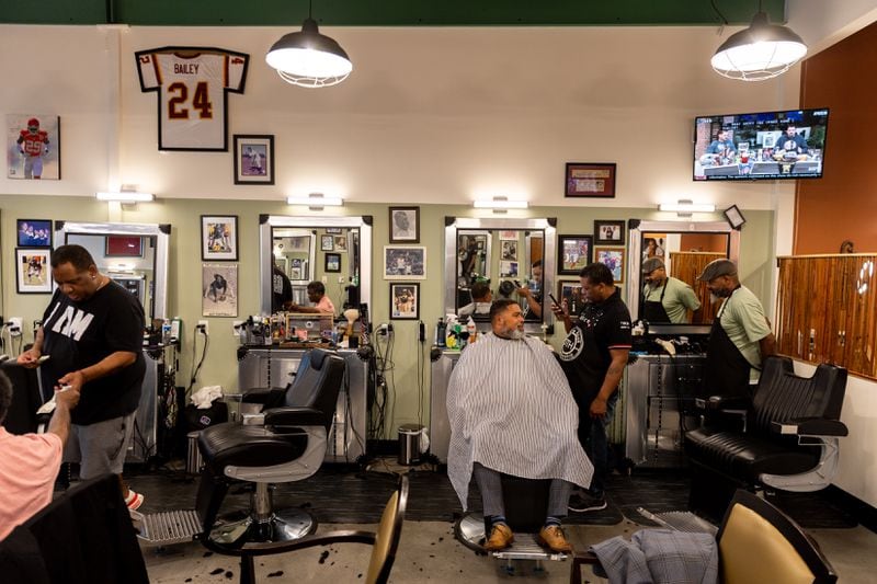 Clients and barbers are seen at Off the Hook Barber Shop in Atlanta on Thursday, May 9, 2024. (Arvin Temkar / AJC)