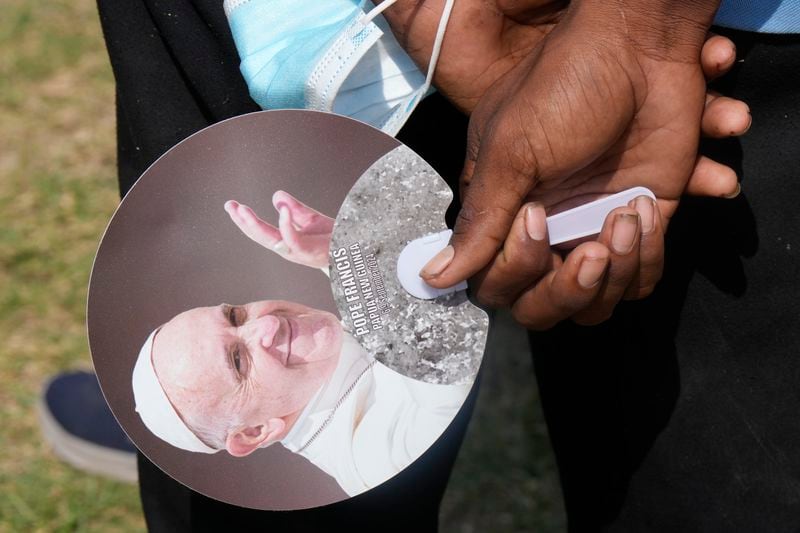 An attendee hold a fan with the Pope's likeness as Pope Francis gives an address during meeting with young people in the Sir John Guise Stadium in Port Moresby, Papua New Guinea, Monday, Sept. 9, 2024. (AP Photo/Mark Baker)