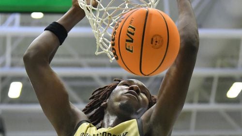 March 4, 2022 Buford - Pebblebrook's Jaiun Simon (3) hangs on the basket after dunking the ball in the second half of 2022 GHSA Basketball Playoffs at Buford Arena on Friday, March 4, 2022. Berkmar won 72-58 over Pebblebrook. (Hyosub Shin / Hyosub.Shin@ajc.com)