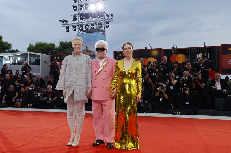 Tilda Swinton, from left, director Pedro Almodovar, and Julianne Moore pose for photographers upon arrival for the premiere of the film 'The Room Next Door' during the 81st edition of the Venice Film Festival in Venice, Italy, on Monday, Sept. 2, 2024. (Photo by Joel C Ryan/Invision/AP)