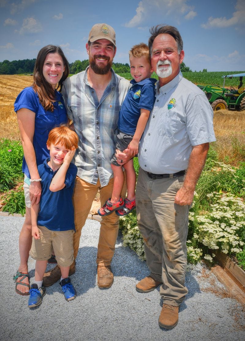 DaySpring Farms is owned by the Brett family. Simone and Nathan Brett live on the farm with their sons, 4-year-old Theo (in Nathan's arms) and 6-year-old Noah. With them is Nathan's father, Murray Brett. DaySpring Farms is an organic certified farm that grows, harvests and mills grains on-site. (Chris Hunt for The Atlanta Journal-Constitution)