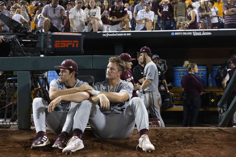 Texas A&M's Ryan Prager, right, sits with Hayden Schott as they watch Tennessee celebrate their 6-5 victory in Game 3 of the NCAA College World Series baseball finals in Omaha, Neb., Monday, June 24, 2024. (AP Photo/Rebecca S. Gratz)