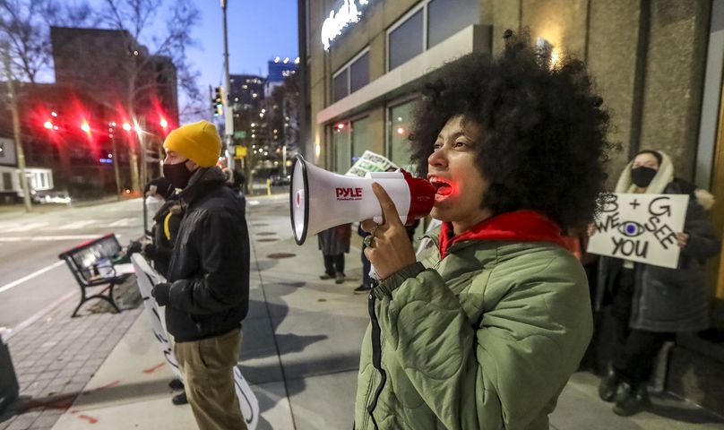 Mariah Parker with The People Stop Work Order uses a bullhorn to lead chants as law enforcement try to extricate two protesters from construction equipment. Two people locked themselves to construction equipment in Midtown to protest Atlanta’s planned public safety training center, causing a street to close amid the Monday morning commute, Jan. 29, 2024. The activists used reinforced bindings to lock their arms around the equipment at a Brasfield & Gorrie work site at 12th and Juniper streets. One person was locked to a construction elevator and the other to a boom. Both were released by 10:15 a.m. Juniper Street was closed to traffic for hours Monday morning before reopening around 11:30 a.m. SWAT team members were also at the scene for assistance in cutting the activists free. Brasfield & Gorrie is one of the contractors hired to build the training facility at the site of the old Atlanta Prison Farm in the south DeKalb County woods. Those opposed to the facility say its construction will damage the South River Forest and contribute to what they say is the militarization of the police department. (John Spink / John.Spink@ajc.com)

