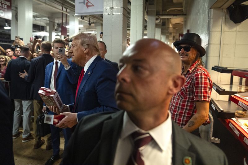 Republican presidential nominee former President Donald Trump and Kid Rock leave a concession stand during the Georgia vs. Alabama football game at Bryant-Denny Stadium, Saturday, Sept. 28, 2024, in Tuscaloosa, Ala. (AP Photo/Evan Vucci)