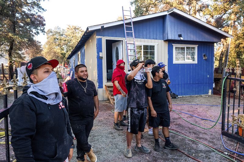 Residents watch as firefighters mop up at a home destroyed by the Boyles fire in Clearlake, Calif., on Sunday, Sept. 8, 2024. (AP Photo/Noah Berger)