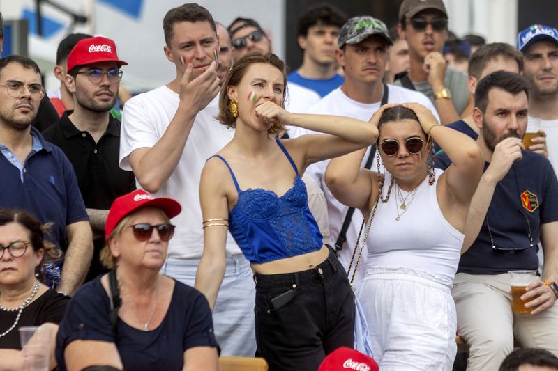 People watch a round of sixteen match between Switzerland and Italy at the Euro 2024 soccer tournament in Germany during a public viewing in Milan, Italy, Saturday, June 29, 2024. (Stefano Porta/LaPresse via AP)