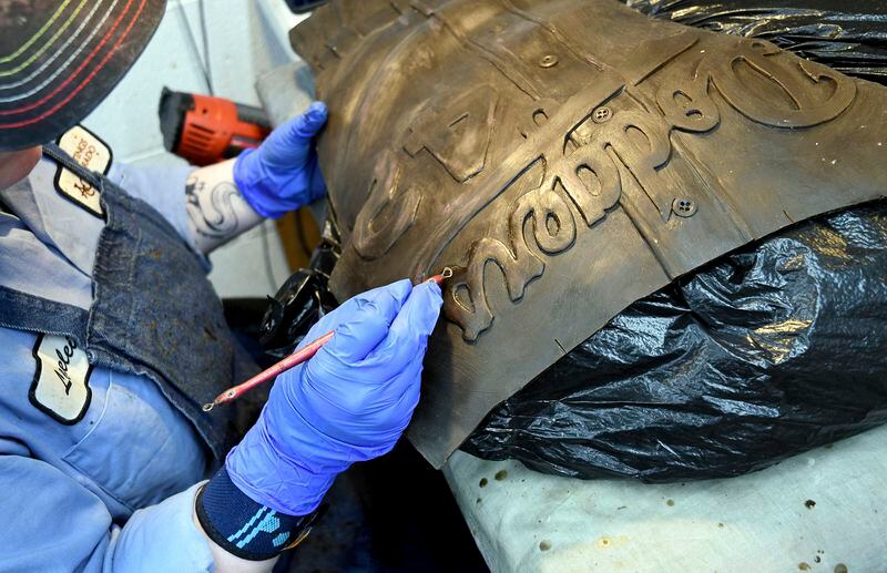 An employee at Art Castings of Colorado touches up a wax mold of Jackie Robinson's jersey in Loveland, Colo. on Wednesday, May 8, 2024. The original statue was cut off at the ankles and stolen from a park in Wichita, Kansas in January. The Colorado foundry cast that sculpture in 2019 and, luckily, still had the original plaster and rubber molds. (AP Photo/Thomas Peipert)