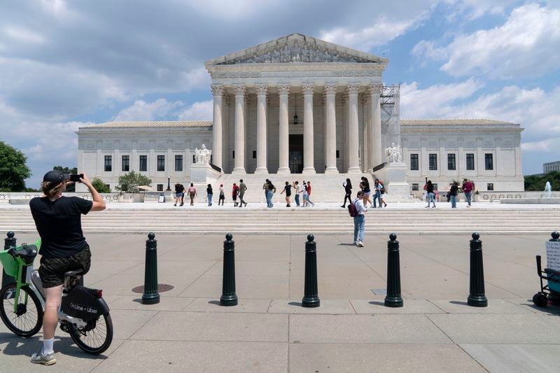 Visitors pose for photographs at the U.S. Supreme Court Tuesday, June 18, 2024, in Washington. ( AP Photo/Jose Luis Magana)