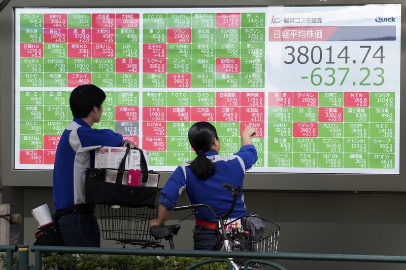 People watch an electronic stock board showing Japan's Nikkei index at a securities firm Wednesday, Oct. 2, 2024, in Tokyo. (AP Photo/Eugene Hoshiko)