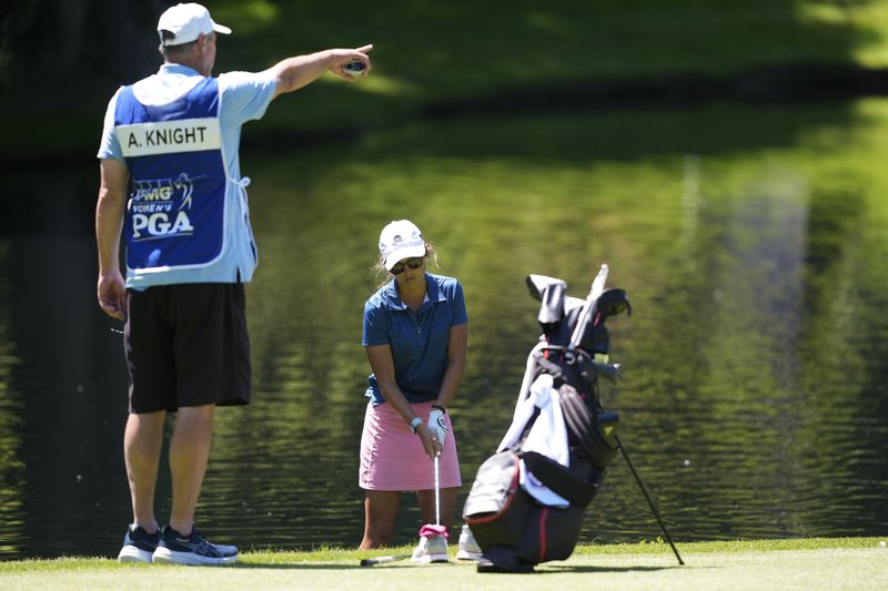 Allie Knight stands in the water to take a shot on the 10th hole during the first round of the Women's PGA Championship golf tournament at Sahalee Country Club, Thursday, June 20, 2024, in Sammamish, Wash. (AP Photo/Gerald Herbert)