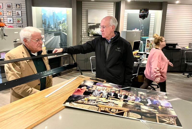 Chuck Wolf, longtime photo guy, left, speaks with customer Martin Tilson at his store.