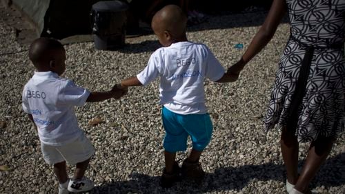 FILE - Haitian children walk hand in hand as they await the arrival of their adoptive parents in Port-au-Prince, Haiti, Dec. 21, 2010. (AP Photo/Ramon Espinosa, File)