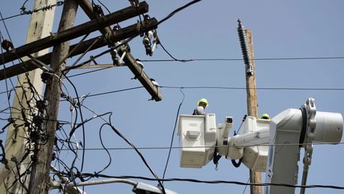 FILE - A brigade from the Electric Power Authority repairs distribution lines damaged by Hurricane Maria in the Cantera community of San Juan, Puerto Rico, Oct. 19, 2017. A federal judge overseeing a drawn-out debt-restructuring process for the power company ordered all parties to mediation on Wednesday, July 10, in the latest attempt to break an impasse that has sparked widespread anger and frustration. (AP Photo/Carlos Giusti, File)