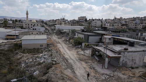 A man walks on a damaged road following an Israeli army raid in Jenin, West Bank, on Wednesday, Sept. 4, 2024. (AP Photo/Majdi Mohammed)